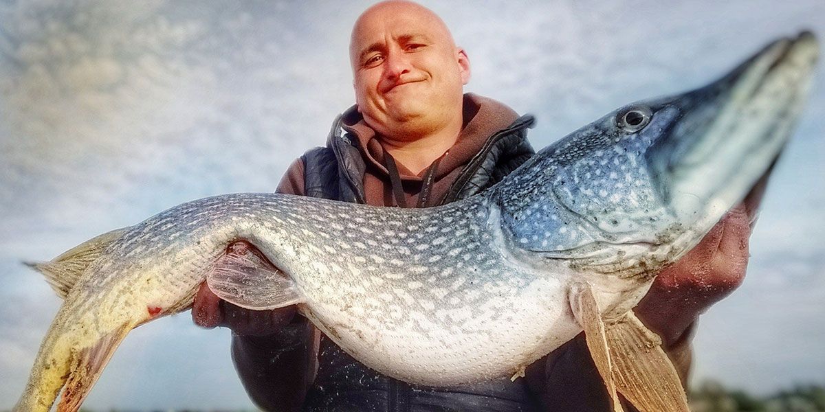 Angler posing with pike fish