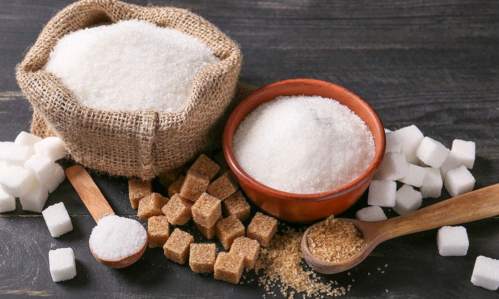 Brown and white sugar cubes and containers