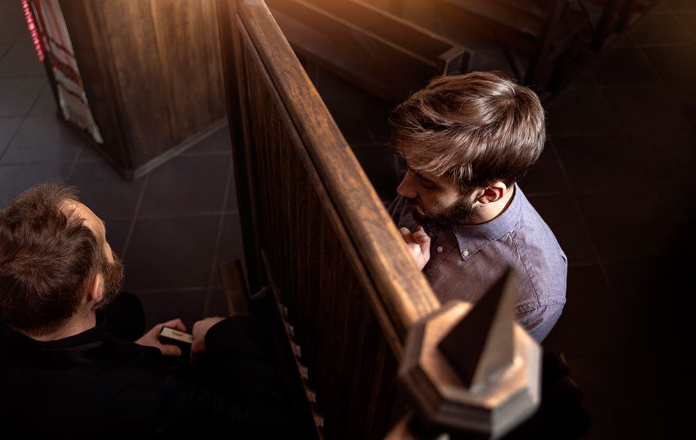 Close up on priest hearing a confession of man