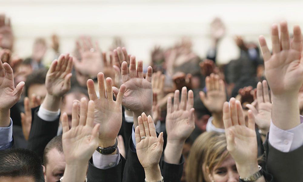 Crowd of people raising hands up