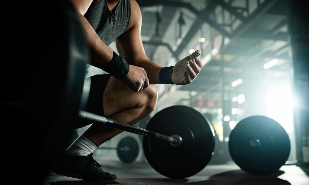 Muscular man preparing to lift barbell in the fitness club